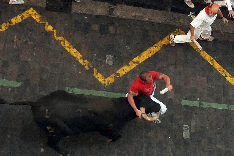 Un hombre corre cogido al toro