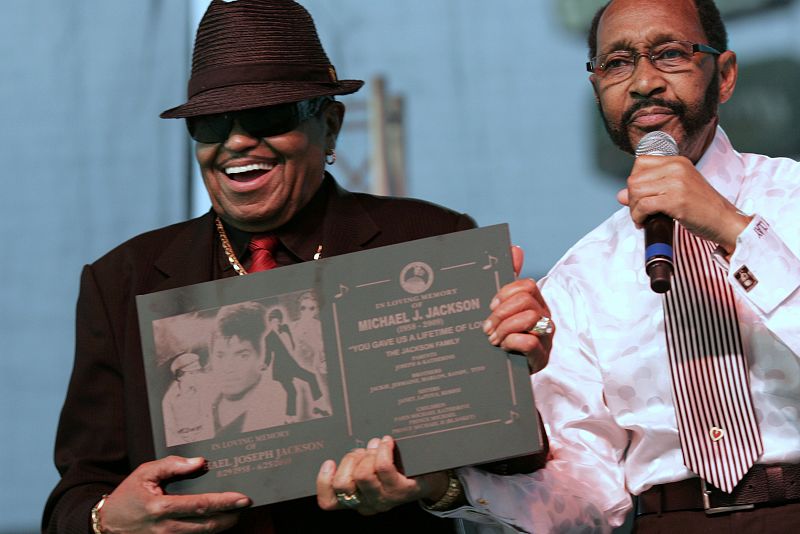 Joe Jackson, padre de Michael Jackson, recibe una placa conmemorativa de manos del alcalde de Gary, Rudy Clay.