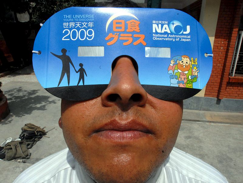 Bharat Aryal, director de la Academia Takshashila usa gafas especiales mientras acude a una clase de preparación sobre cómo ver el eclipse solar en Katmandú (Nepal).