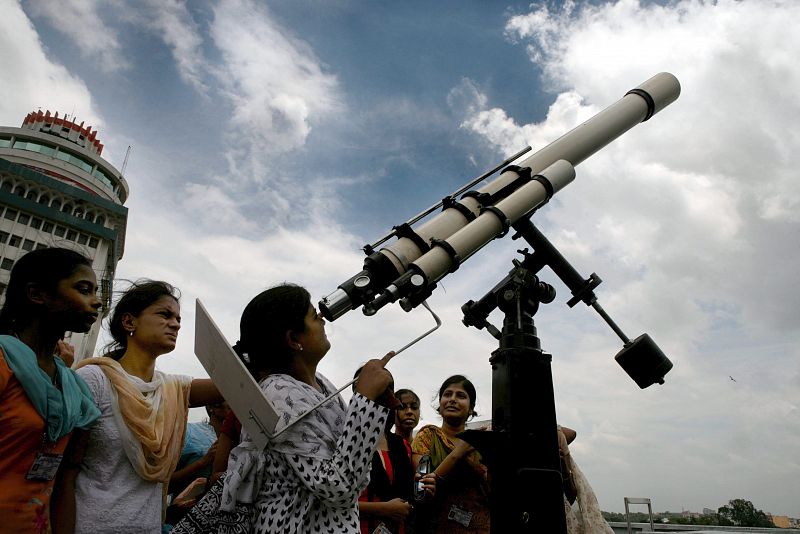 Científicos indios comprueban sus telescopios instalados en el museo de ciencias, un día antes de que se produzca un eclipse solar total, en Patna, India.