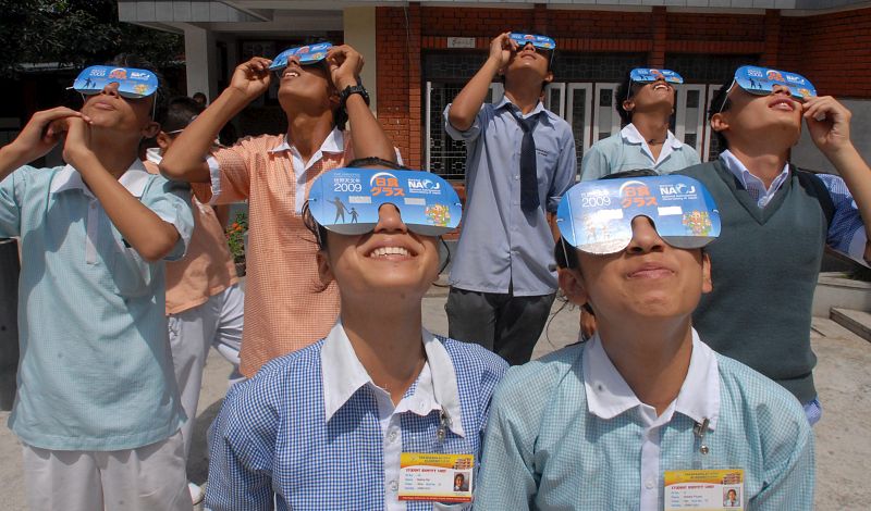 Estudiantes de la Academia Takshashila usan gafas especiales mientras acuden a una clase de preparación para poder ver el eclipse solar en Katmandú (Nepal).