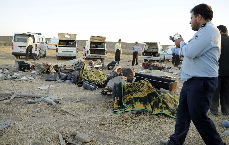 A member of Iran's Air Force takes photographs at the site of the wreckage of a passenger airplane in Mashhad