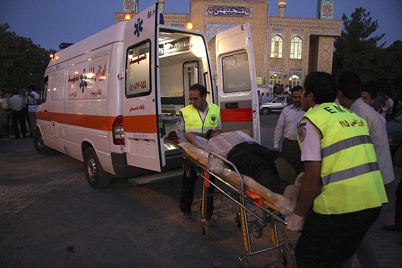 Emergency workers transport a victim of a passenger airplane crash in Mashhad