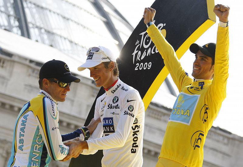 Astana rider and leader's yellow jersey Contador celebrates his overall victory as Saxo Bank rider and white jersey for best youngster Schleck shakes hands with Astana rider Armstrong after the final stage of the Tour de France cycling race