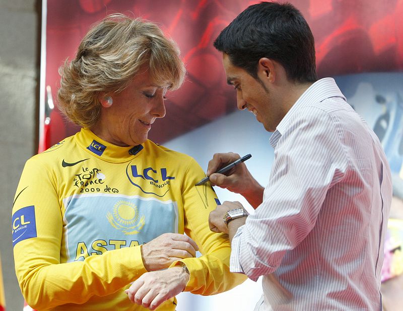 El ciclista español firma un autógrafo en el maillot amarillo a la presidenta de la Comunidad de Madrid, Esperanza Aguirre.