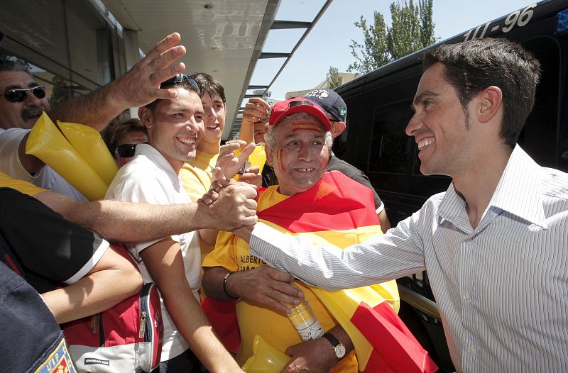 El ciclista español saluda a un grupo de aficionados que se desplazaron hasta Barajas para darle la bienvenida.