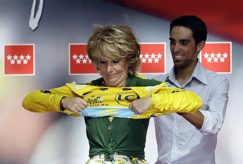 Contador ayuda a Esperanza Aguirre a enfundarse el maillot amarillo.