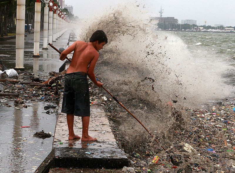 FILIPINO SCAVENGERS COLLECT USEFUL MATERIALS BROUGHT BY STRONG WAVES AT MANILA BAY,