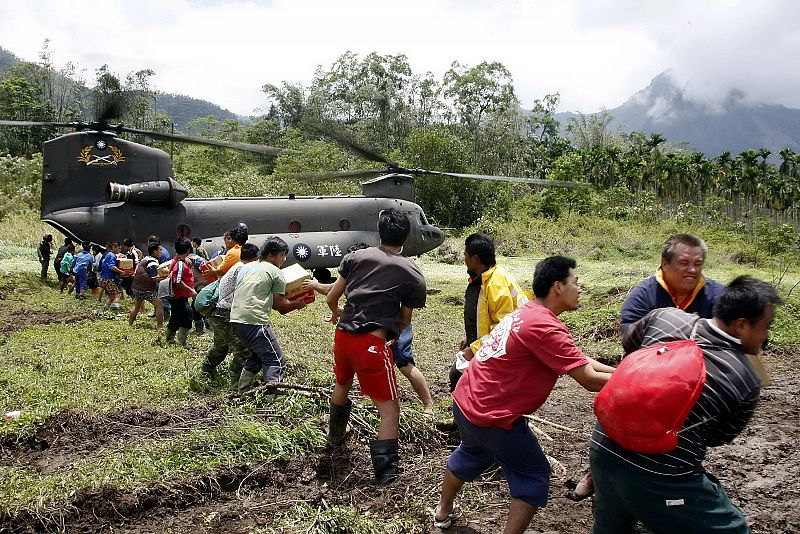 Handout from Taiwan Military News Agency shows people helping to convey supplies from army CH-47 Chinook transport helicopter in flooded village in Kaohsiung county