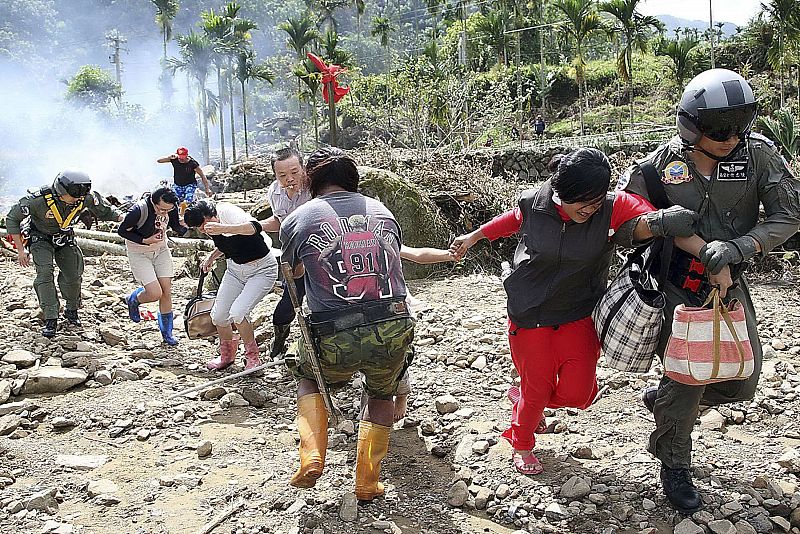 A handout photograph from the Taiwan Military News Agency shows soldiers helping survivors evacuate from a mudslide affected village of Laiji after Typhoon Morakot in Chiayi county