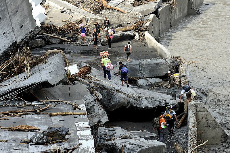 People walk toward their homes at the landslide affected villages in the mountains of Pingtung County following Typhoon Morakot