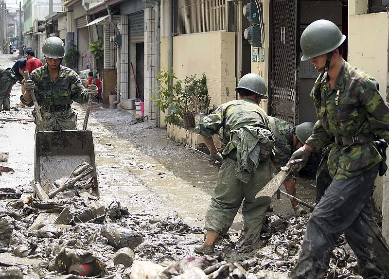 A handout photograph from the Taiwan Military News Agency shows soldiers cleaning up mud from a flooded village after Typhoon Morakot in Chiayi county, southern Taiwan