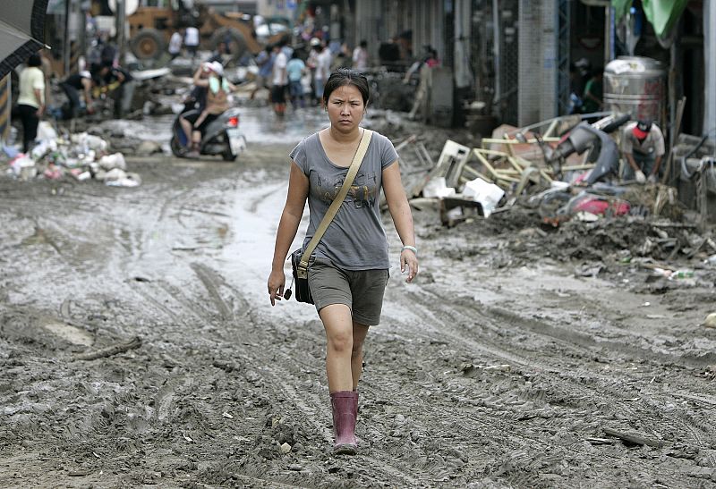 A woman walks in a mud-covered street after Typhoon Morakot swept Taiwan at Chishan township in Kaohsiung county