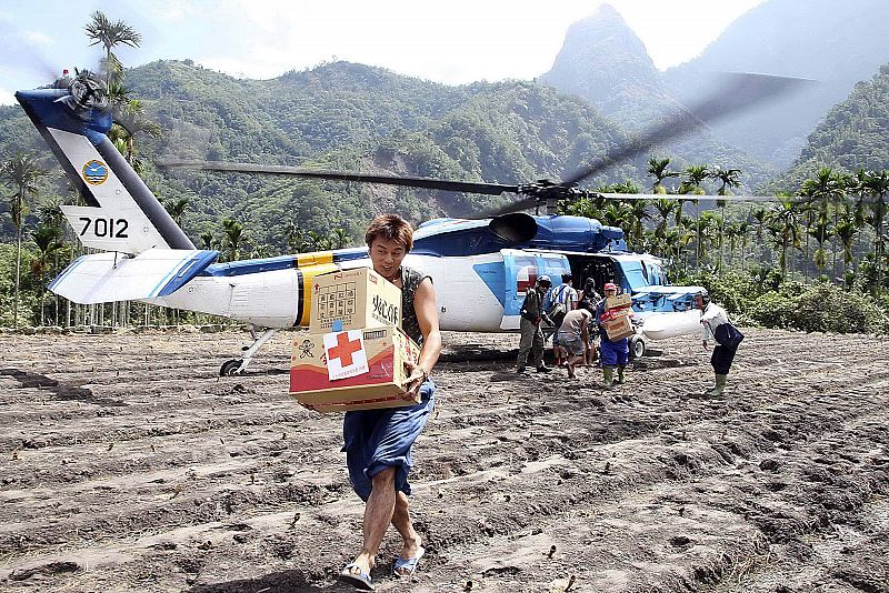 Handout photo of survivors carrying supplies from helicopter to mudslide affected village of Laiji in Chiayi county