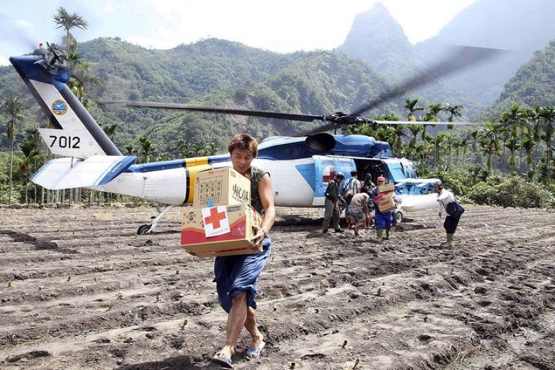 Handout photo of survivors carrying supplies from helicopter to mudslide affected village of Laiji in Chiayi county
