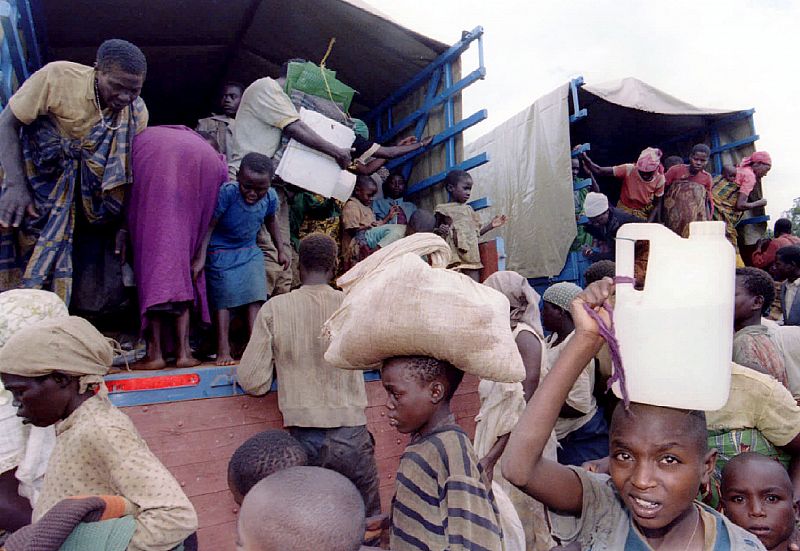 Hutu refugees jump out of trucks in a transit camp in a village in southern Rwanda April 29 after ar..