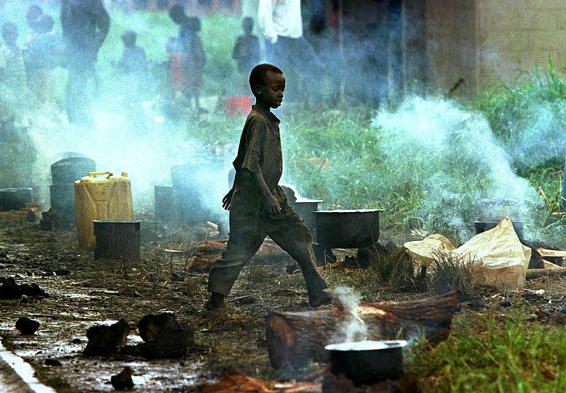 YOUNG CHILD WALKS THROUGH REFUGEE CAMP AFTER RETURNING FROM ZAIRE TO