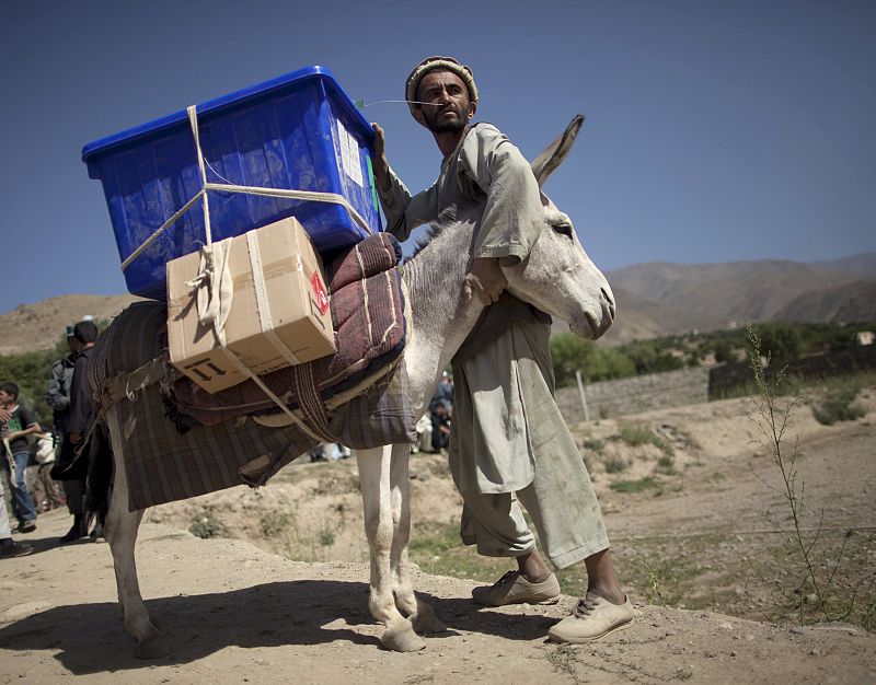 A man holds his donkey carrying election supplies before they departed to a rural polling station in Afghanistan's mountainous Panjshir Province