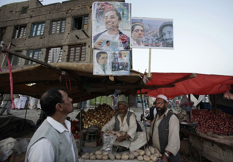 Vendors sell vegetables under a poster for presidential candidate Abdullah Abdullah in Kabul