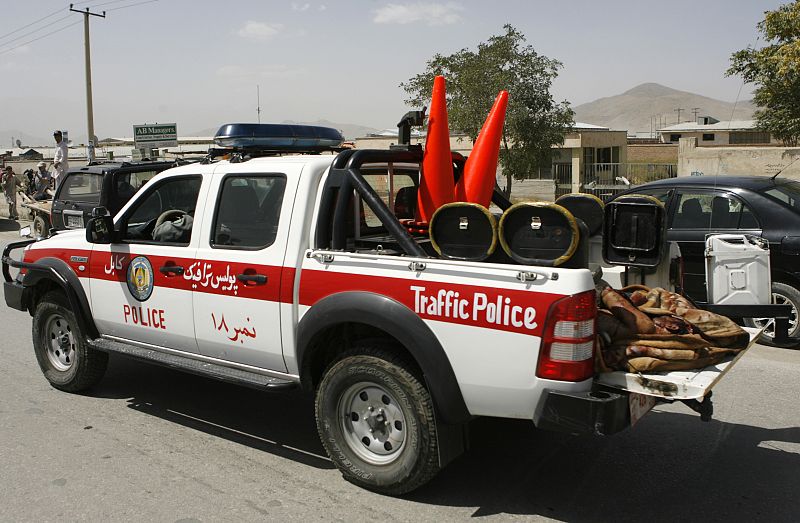 A traffic police car carries a body away from the scene of a suicide attack in Kabul