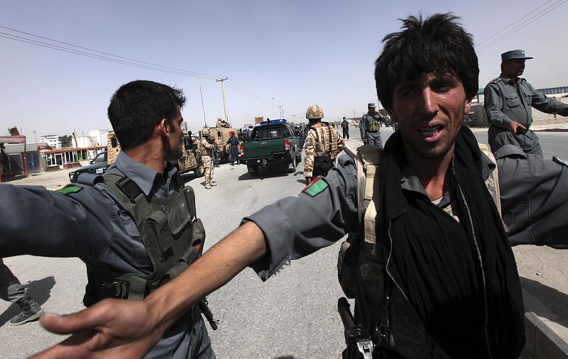 Afghan policeman secure the area of a suicide attack in Kabul