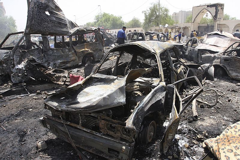 Burned vehicles lie damaged outside the Foreign Ministry building after a bomb attack in Baghdad