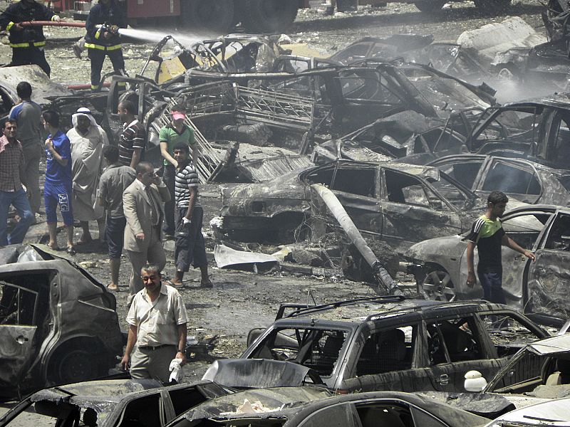 Residents gather at the site of a truck bomb attack outside the Iraqi Ministry of Foreign Affairs in Baghdad