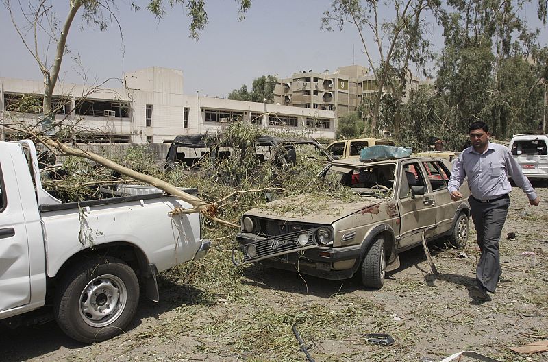 A resident walks past damaged vehicles after a truck bomb attack outside the Iraqi Ministry of Foreign Affairs in Baghdad