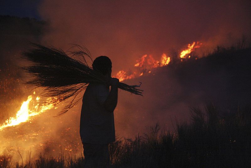 Un vecino de Serradilla se dispone a enfrentarse al fuego que está quemando encina y monte bajo a menos de dos kilómetros del casco urbano de Serradilla del Arroyo, al oeste de la provincia de Salamanca. Para sofocar el incendio, cuyas causas aún se