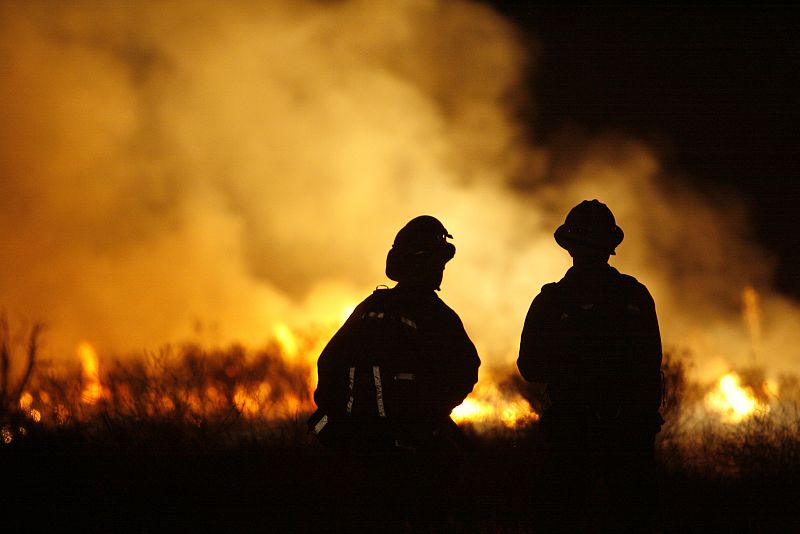 Los Angeles County firefighters watch as the Station fire burns in the Acton area of Los Angeles