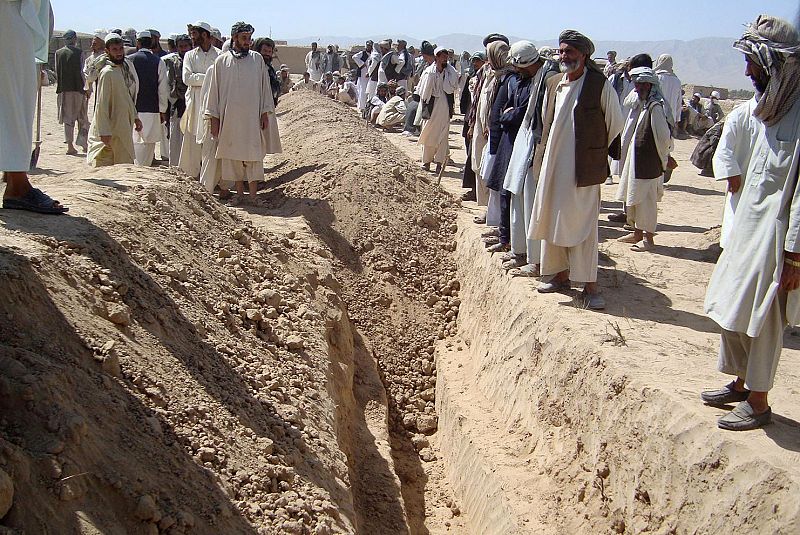 Afghans bury some of the victims of an airstrike in a mass grave near Kunduz