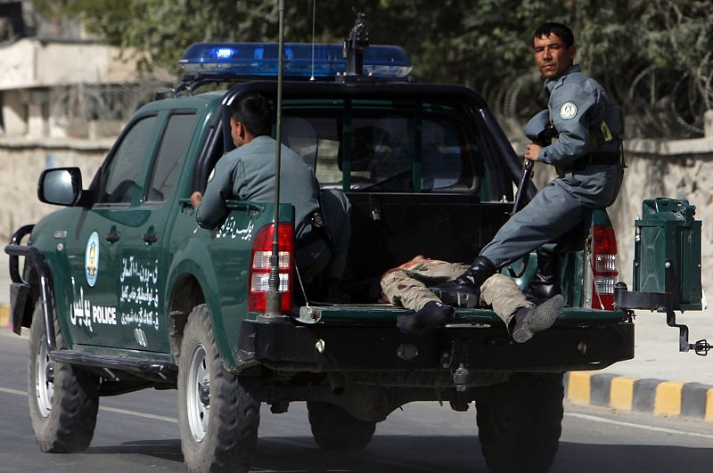 Afghan policemen drive a casualty away from a blast site outside a NATO military base in Kabul