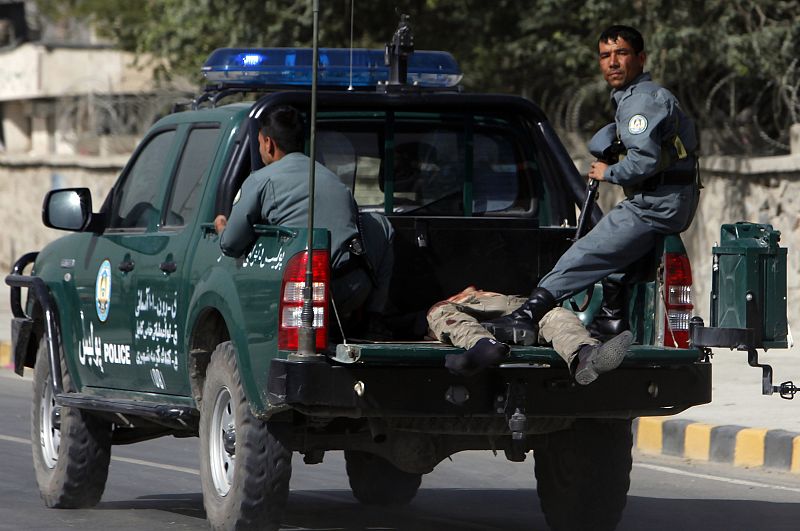 Afghan policemen drive a casualty away from a blast site outside a NATO military base in Kabul