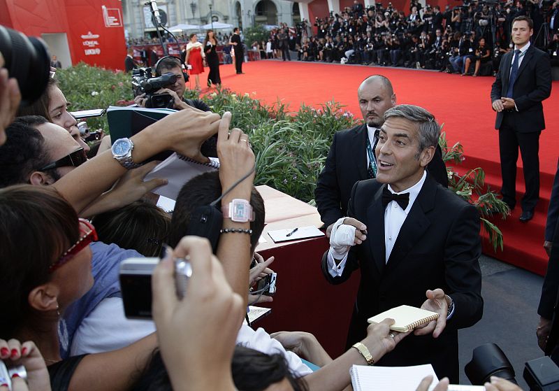 Actor Clooney signs autographs during a red carpet for the premiere of the movie "The Men Who Stare At Goats" at the 66th Venice Film Festival