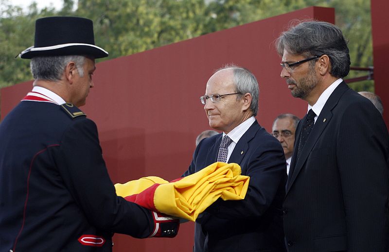 Montilla entrega la senyera a un representante del cuerpo de gala de los Mossos.