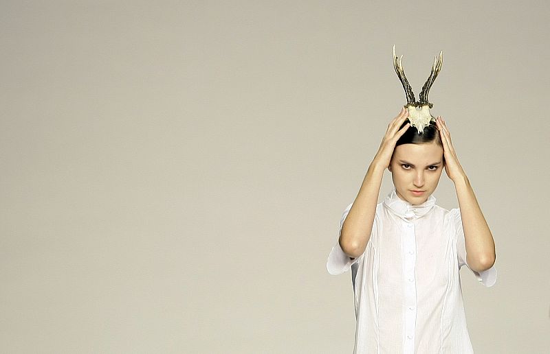 Una de las modelos se ajusta su tocado durante el desfile.