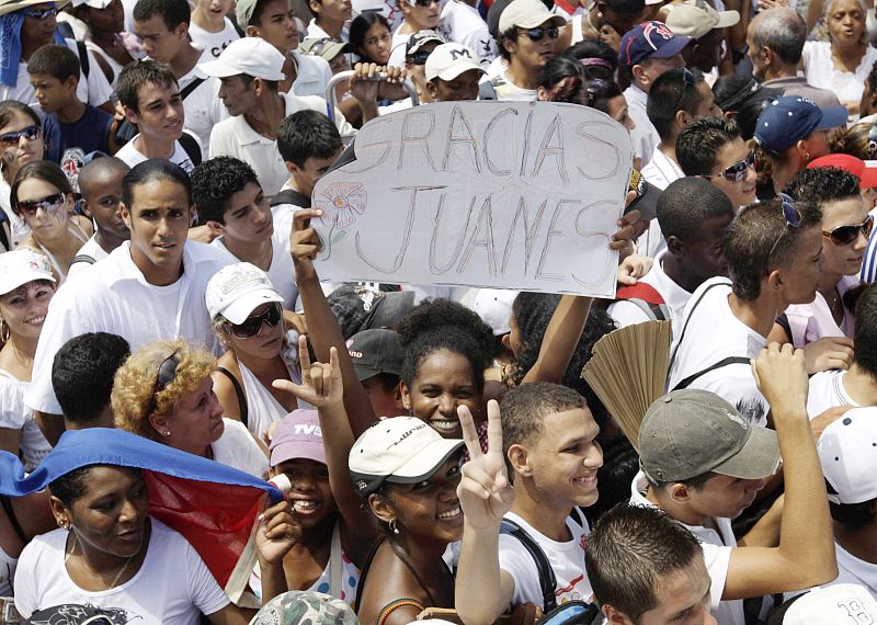 A woman holds up a sign while waiting for the Peace Without Borders concert in Havana's Revolution Square