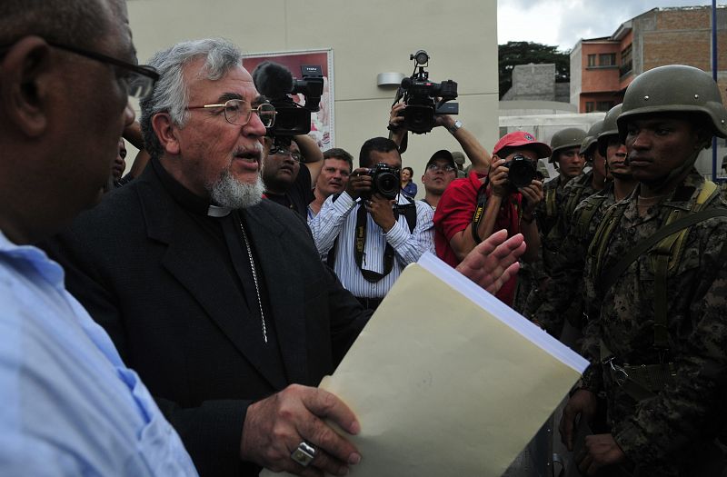 El obispo hondureño Alfonzo Santos (i) trata de entrar en la embajada de Brasil para hablar con Zelaya