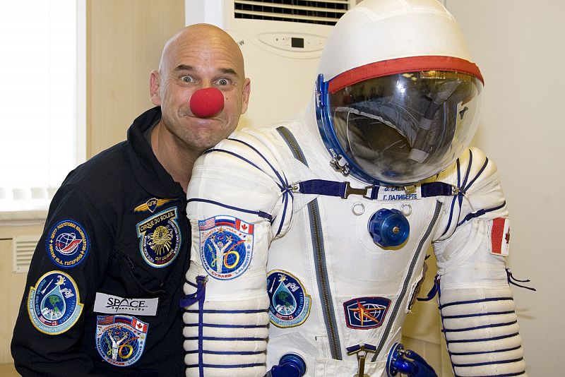 Guy Lalibertè posa junto a su traje espacial en el cosmódromo de Baikonur