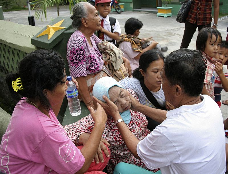 A man comforts a relative after an earthquake hit Padang, on Indonesia's Sumatra island