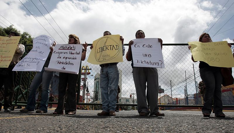 Journalists hold placards demanding for media freedom during a protest in front of the Presidential House in Tegucigalpa