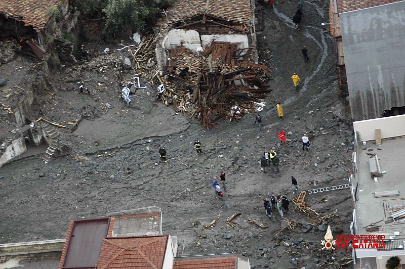 Firefighters help people to evacuate in the village of Scaletta Zanclea near the Sicilian town of Messina