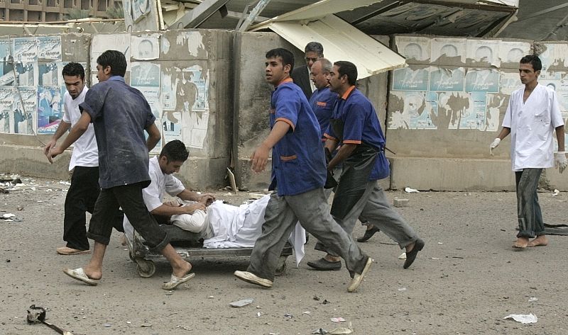 Rescuers take a wounded woman to the nearest hospital after two car bombs targeting the Ministry of Justice and the Baghdad Provincial Council exploded in central Baghdad