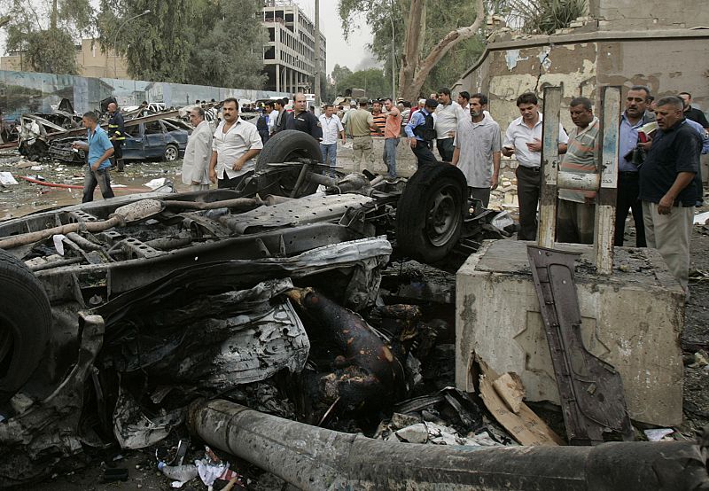 Burnt bodies in an overturned car are seen after two car bombs targeting the Ministry of Justice and the Baghdad Provincial Council exploded in central Baghdad