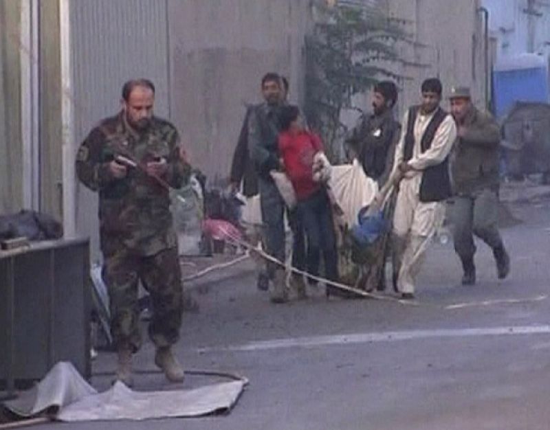 Un hombre transporta a una persona herida envuelta en un manta, tras el atentado en Kabul.