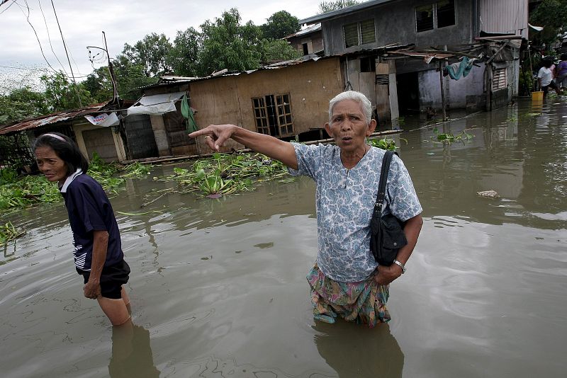 Filipinos atraviesan una calle inundada de la población de Cardona, en la provincia de Rizal (Filipinas).