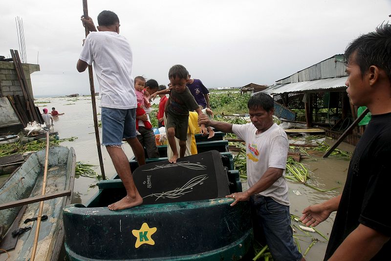 Una familia evacúa su casa durante el paso del tifón 'Miranae', en Taytay, en la provincia de Rizal (Filipinas).