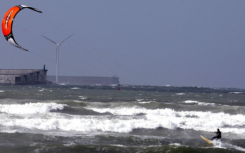 Un kitesurfista, aprovecha la ranchas de viento de 24 nudos en la localidad vizcaína de Getxo como consecuencia del temporal que azota la córnisa cantábrica.