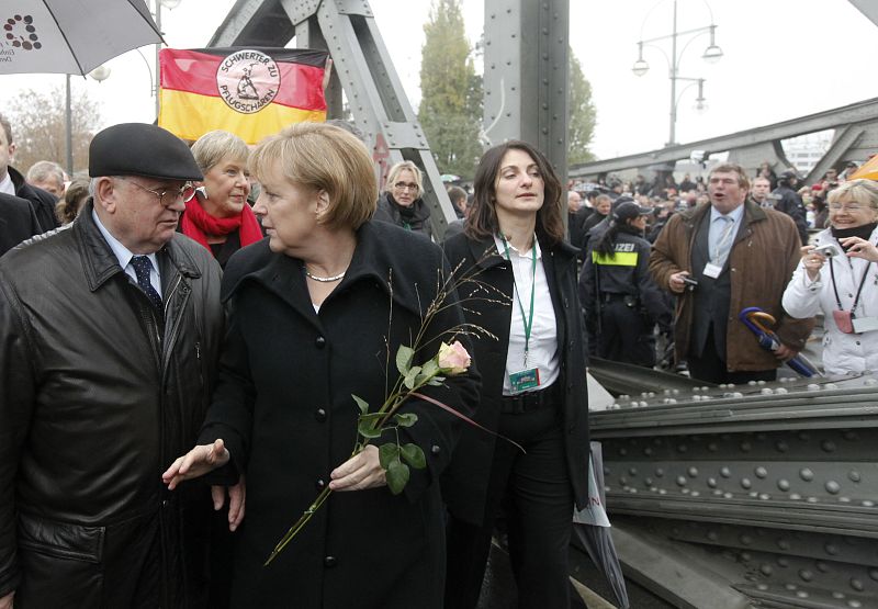 La canciller alemana, Angela Merke, cruza el puente de Bornholmer Strasse, el primer paso fronterizo que se abrió el 9 de noviembre de 1989, junto a Lech Walesa y Mijaíl Gorbachov.