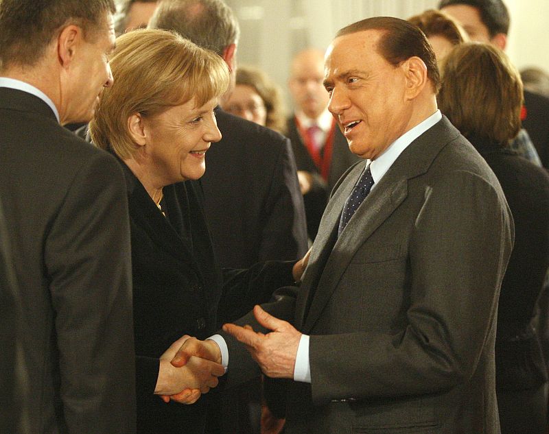 German Chancellor Angela Merkel greets Italian Prime Minister Silvio Berlusconi at a reception at Bellevue Castle in Berlin